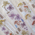 Decorative stickers with flowers and text on a textured surface