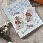 Three small cards with floral designs on top of an open book.