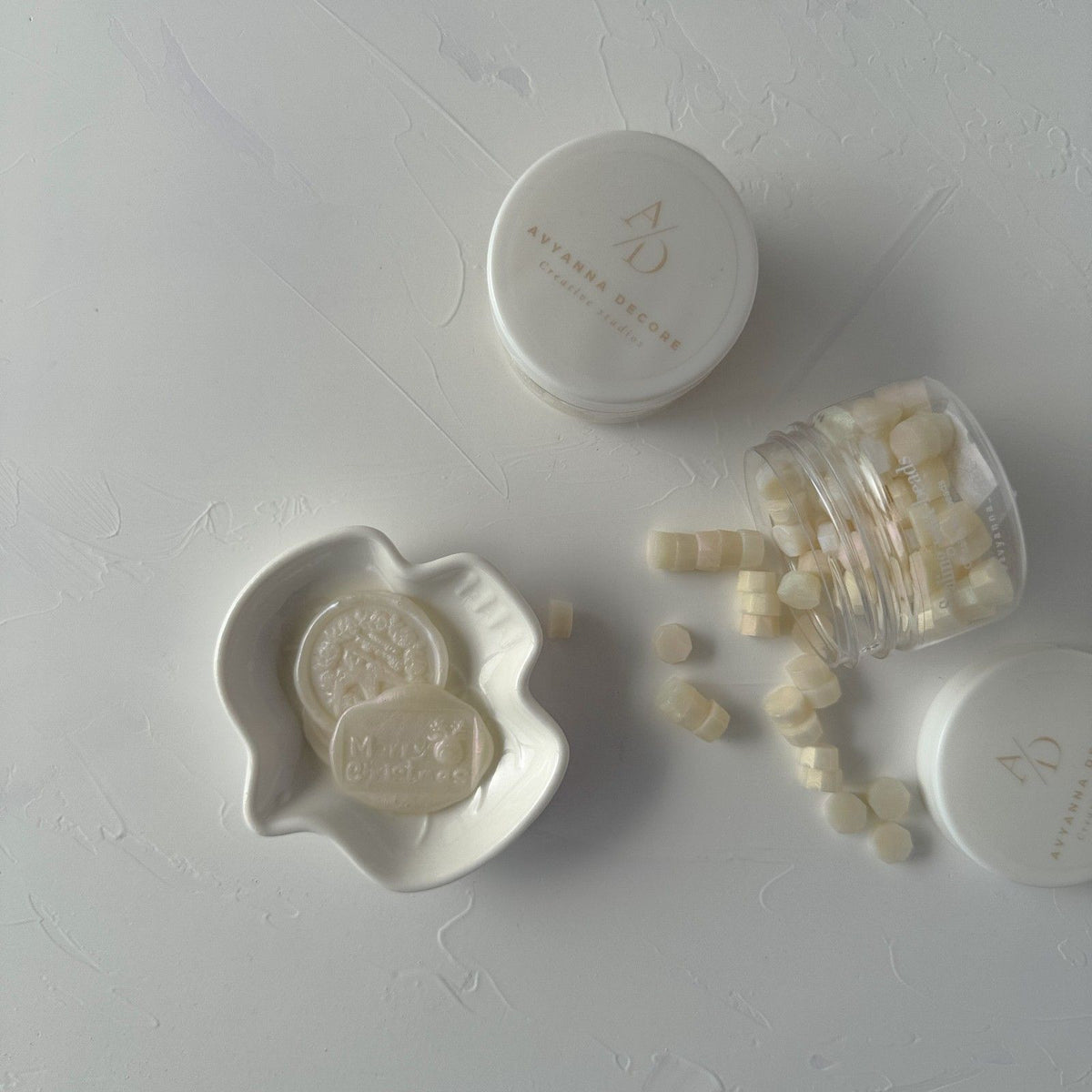 Soft Glow Wax Beads styled with the storage jar, a white dish and small containers on a light grey surface