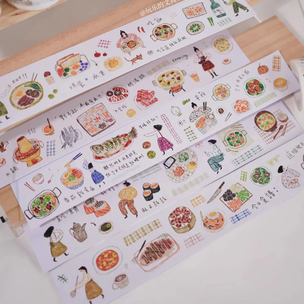 Rolls of Some Delicious Washi Tape with playful food illustrations on a wooden surface