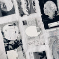 Collection of black and white architectural drawings and prints on a textured surface.