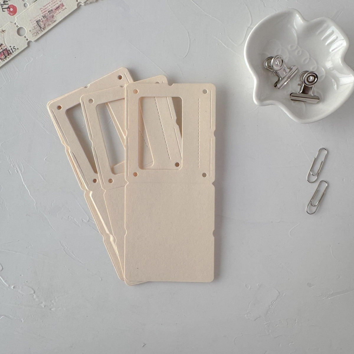 Cream Specimen Card Vol. 1 cards styled with clips and a white container on grey