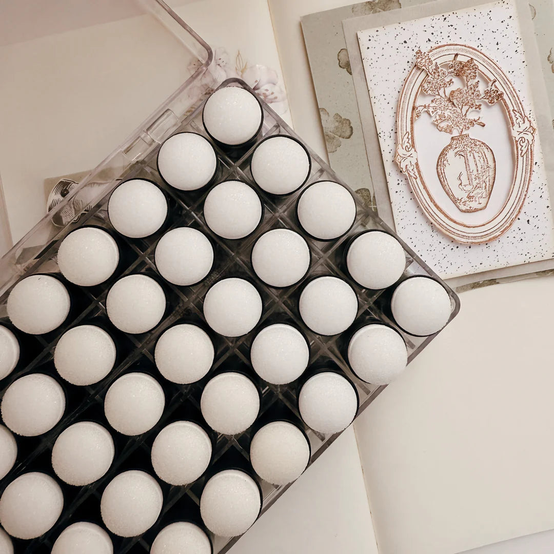 Tray of white spherical objects on a light background