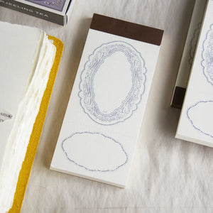 Spring Frame Purple Memo Pad by Loidesign with its decorative cover on a textured surface