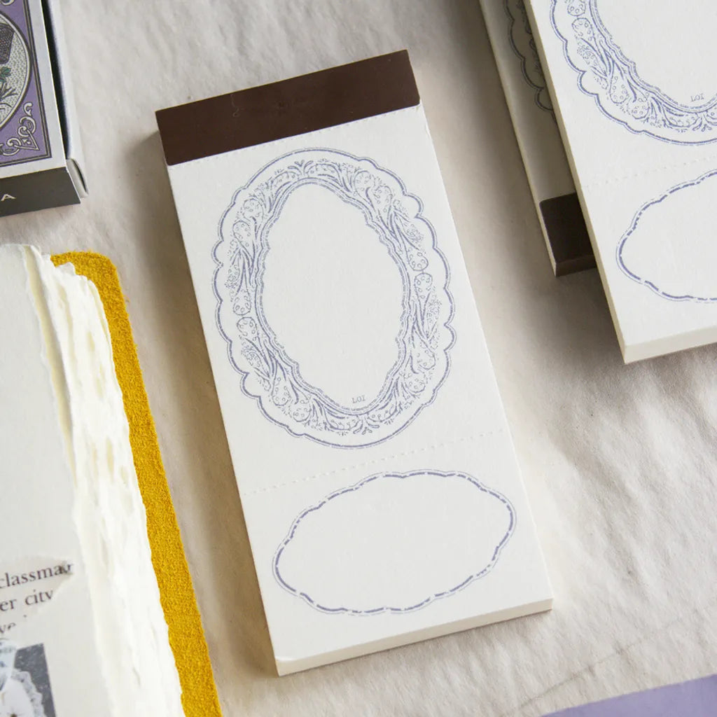 Notebook with decorative oval frames on a marble surface