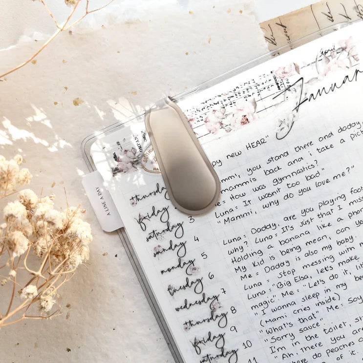 Planner with handwritten notes and a beige Spring Cottage Magnetic Bookmark with flowers