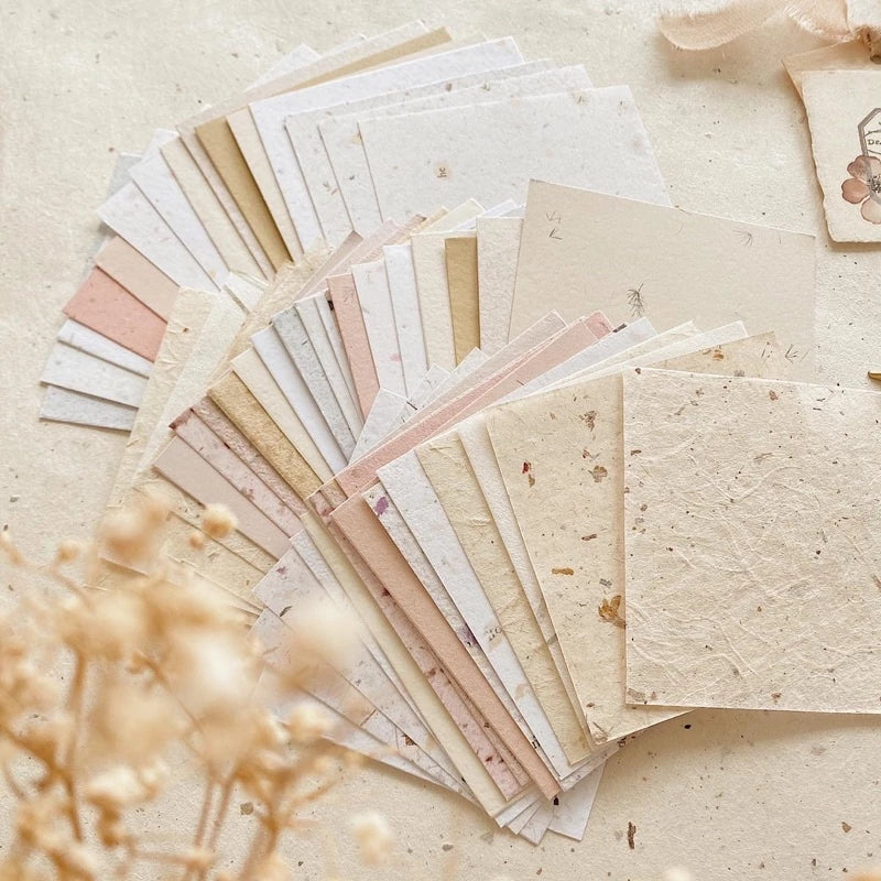 Collection of various textured paper sheets on a light background