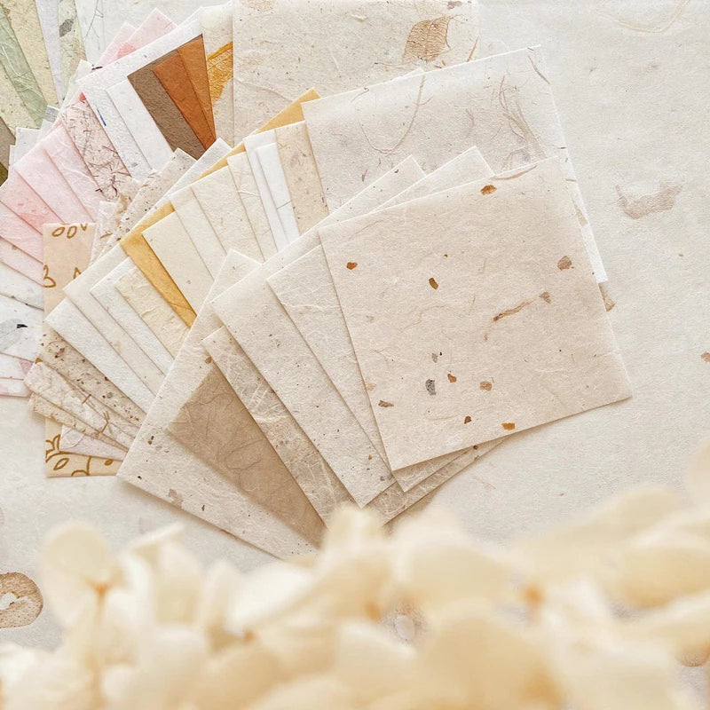 Collection of handmade paper sheets with natural textures on a light background