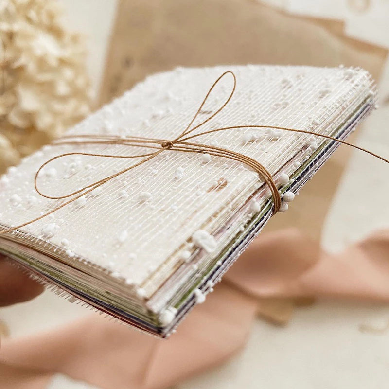 Square Paper Vol. 2 sheets bound as a handmade notebook tied with string, soft focus