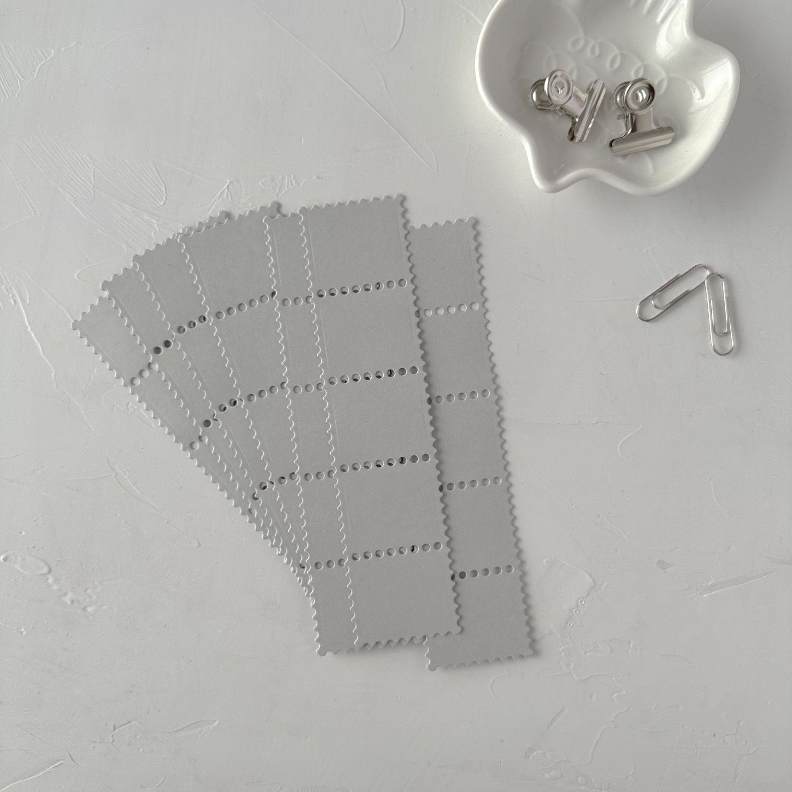 Grey Stamp Card Vol. 1 grid-textured cards on white with a paper clip and binder clip