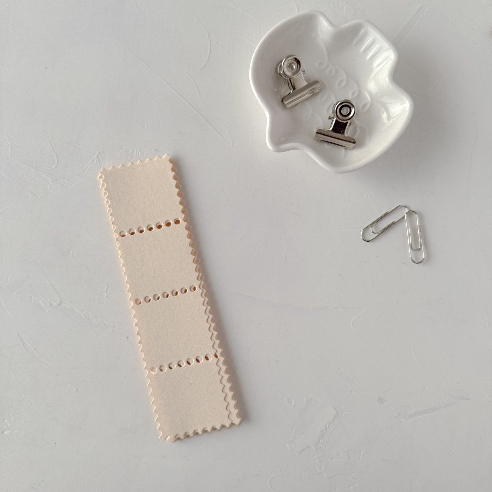 Cream Stamp Card Vol. 2 stitched-look strip with a ceramic holder of clips on light grey