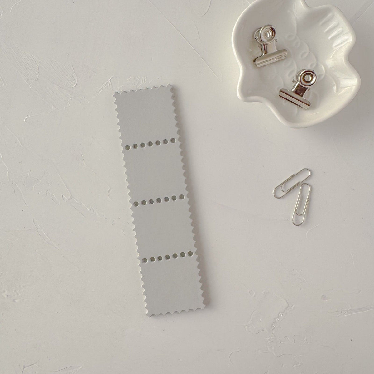 Grey Stamp Card Vol. 2 ephemera card with metal clips on a textured white surface