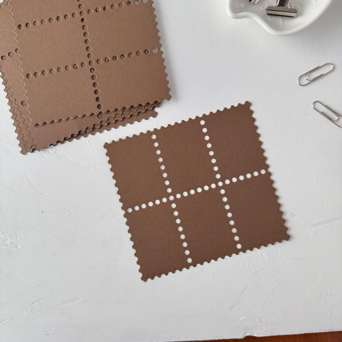 Brown Stamp Card Vol. 3 square ephemera cards with perforated edges on a white surface