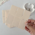 Beige fabric swatches with a star pattern held by a hand on a light gray background