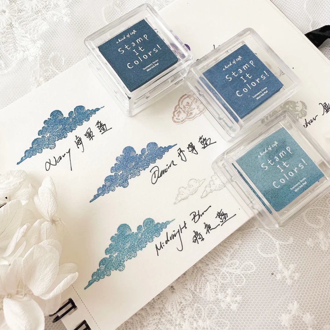 Three stamp ink pads with blue ink on a white surface