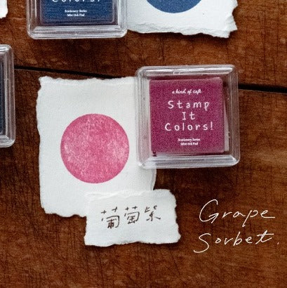 Pink ink pad with a stamp on a wooden surface
