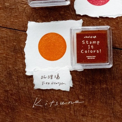 Stamp ink pad with orange stamp on a wooden surface