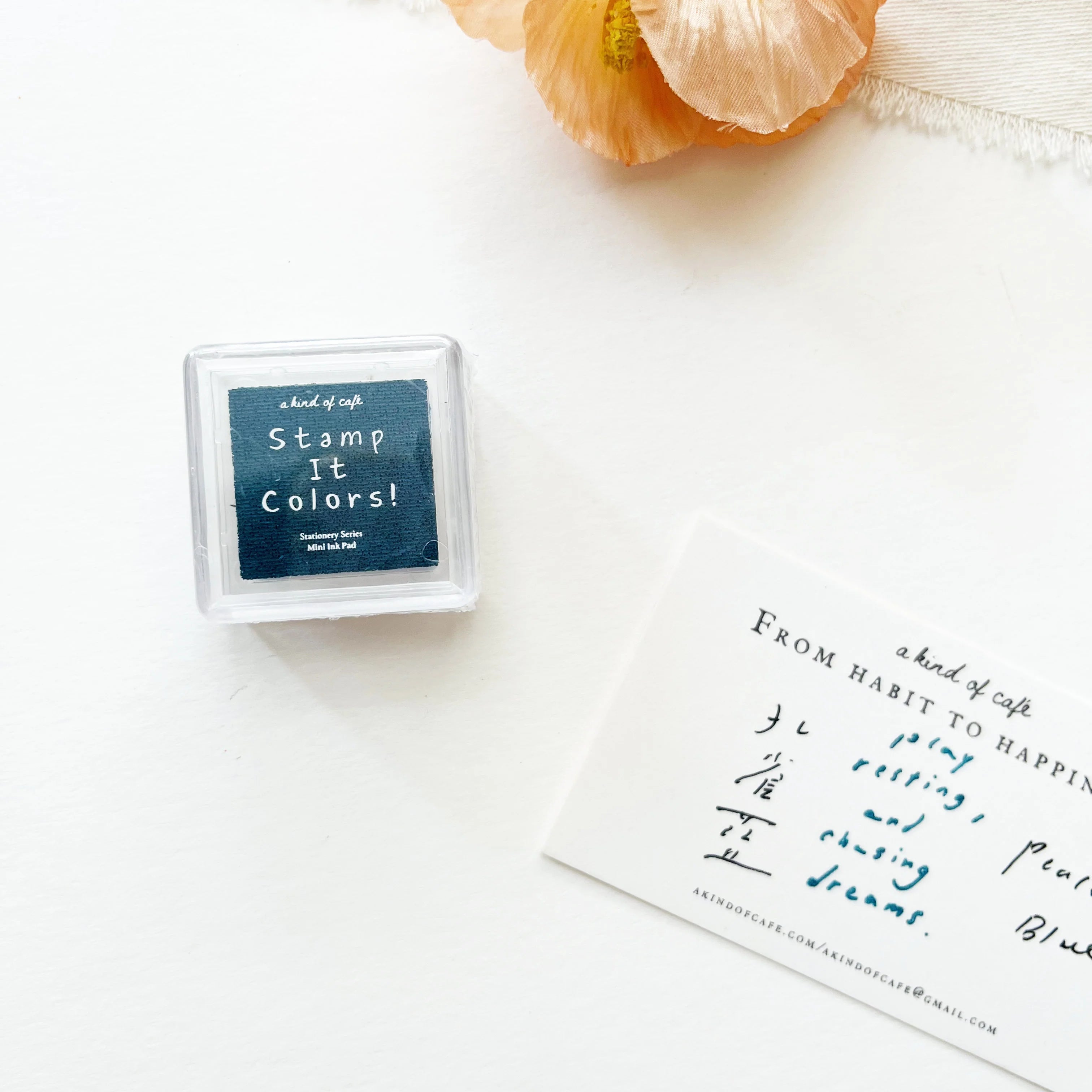 Box of 'Stamp It Colors!' with a piece of paper with handwritten text on a white background.