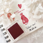 Red stamp with 'Little Happiness' text on a white surface with decorative elements