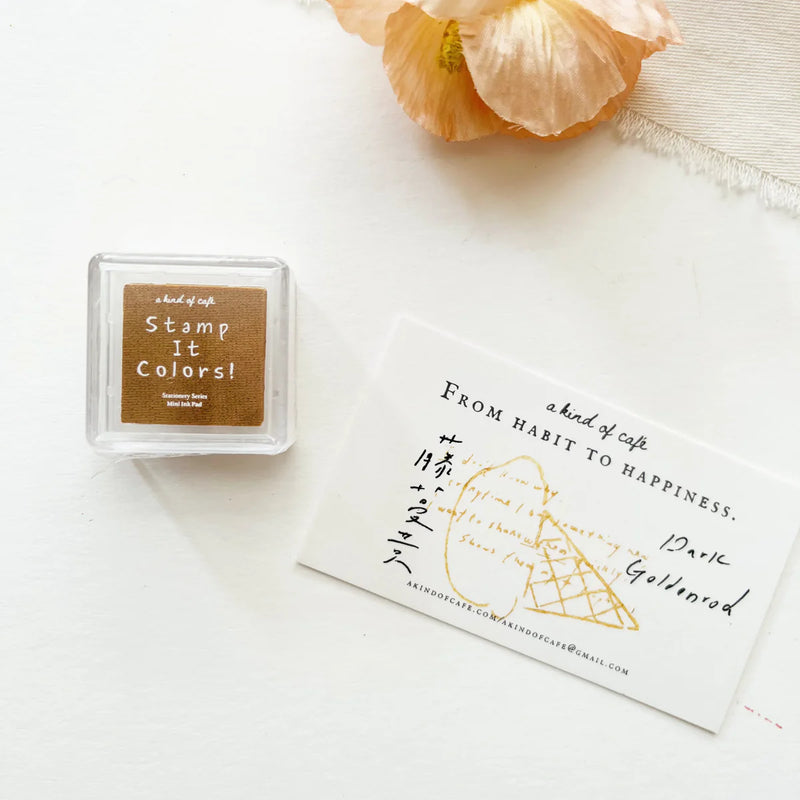 Dark Goldenrod Stamp Ink Pad with Stamp It Colors branding and a flower on a white surface