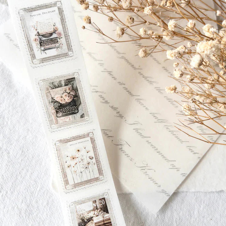 Set of Stamps Washi Tape typewriter designs laid out with dried flowers on a white surface
