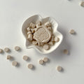 White ceramic dish with decorative elements on a light gray background