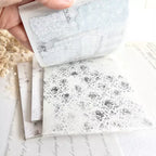 Marble-patterned tiles with a hand holding one of them.