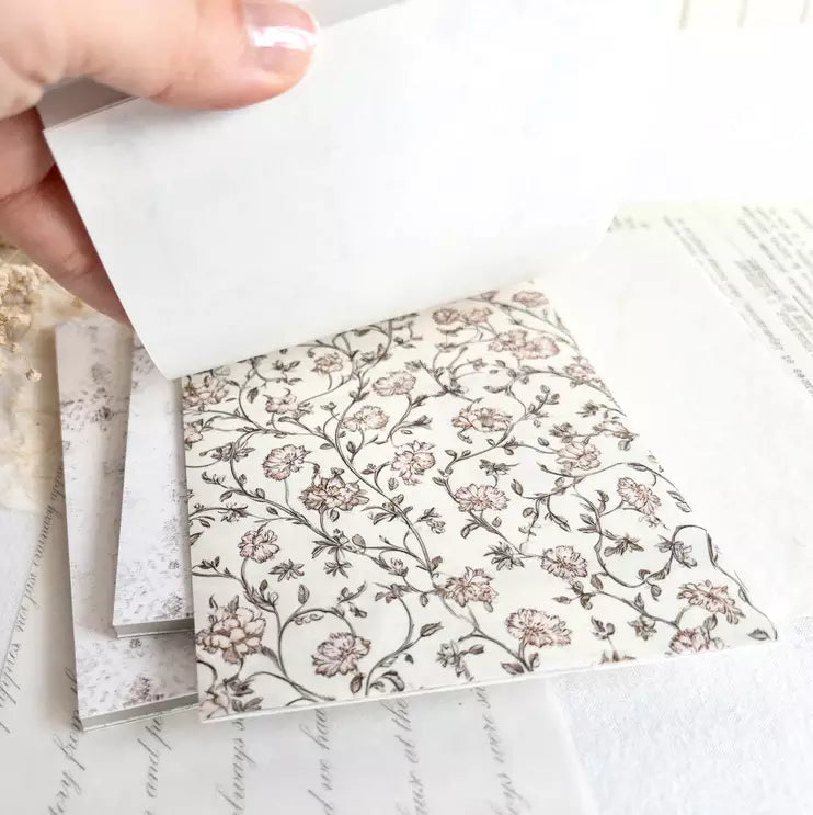 Hand holding a floral sheet from The Vintage One Sticker Book over matching pages