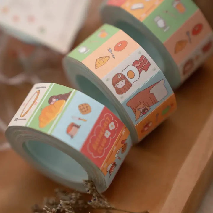 Close-up of Breakfast Club Label Sticker Tape rolls with croissants, bacon and drinks