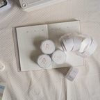 Top view of a monthly planner board with three rolls of pastel “daily life” washi tape and several unrolled strips placed on a soft textured surface.
