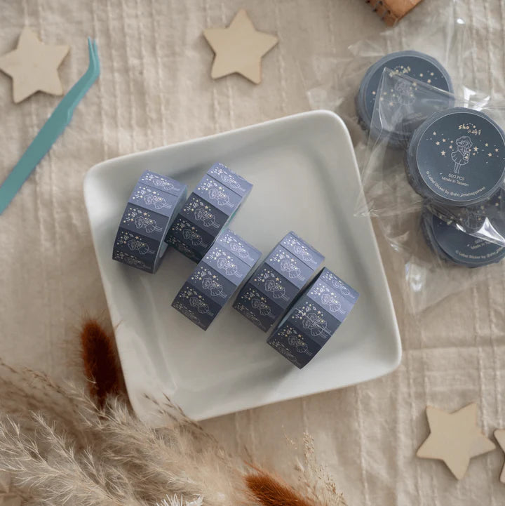 Flat lay of celestial Little Happiness Label Sticker Tape rolls on a white plate