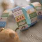Row of pastel washi tape rolls featuring mood tracker designs, including rating stars, party hats, and label spaces for daily notes.