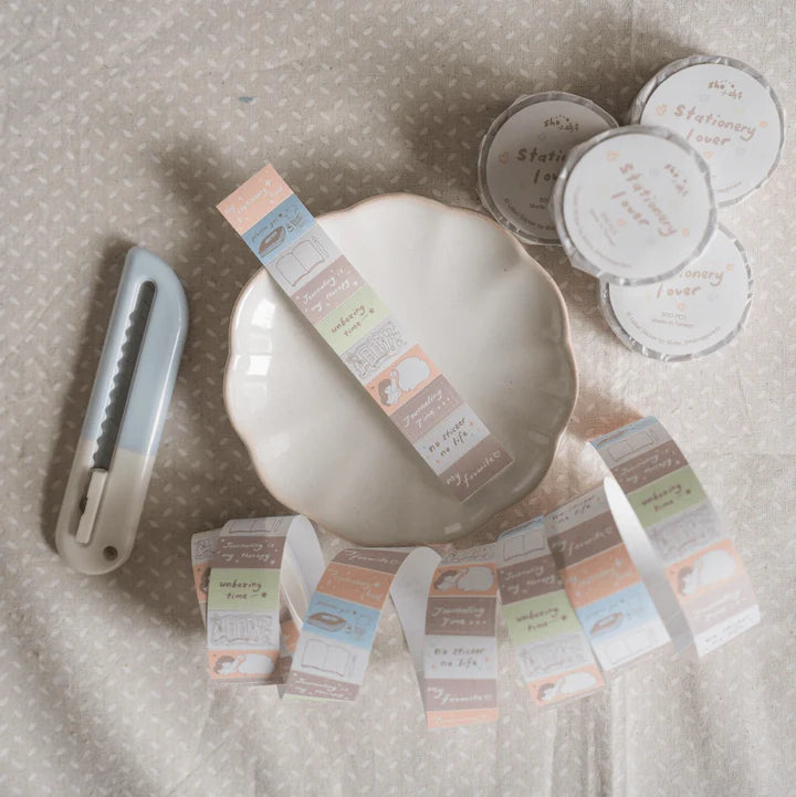 Flat lay of Stationery Lover Label Sticker Tape rolls around a dish with a craft cutter