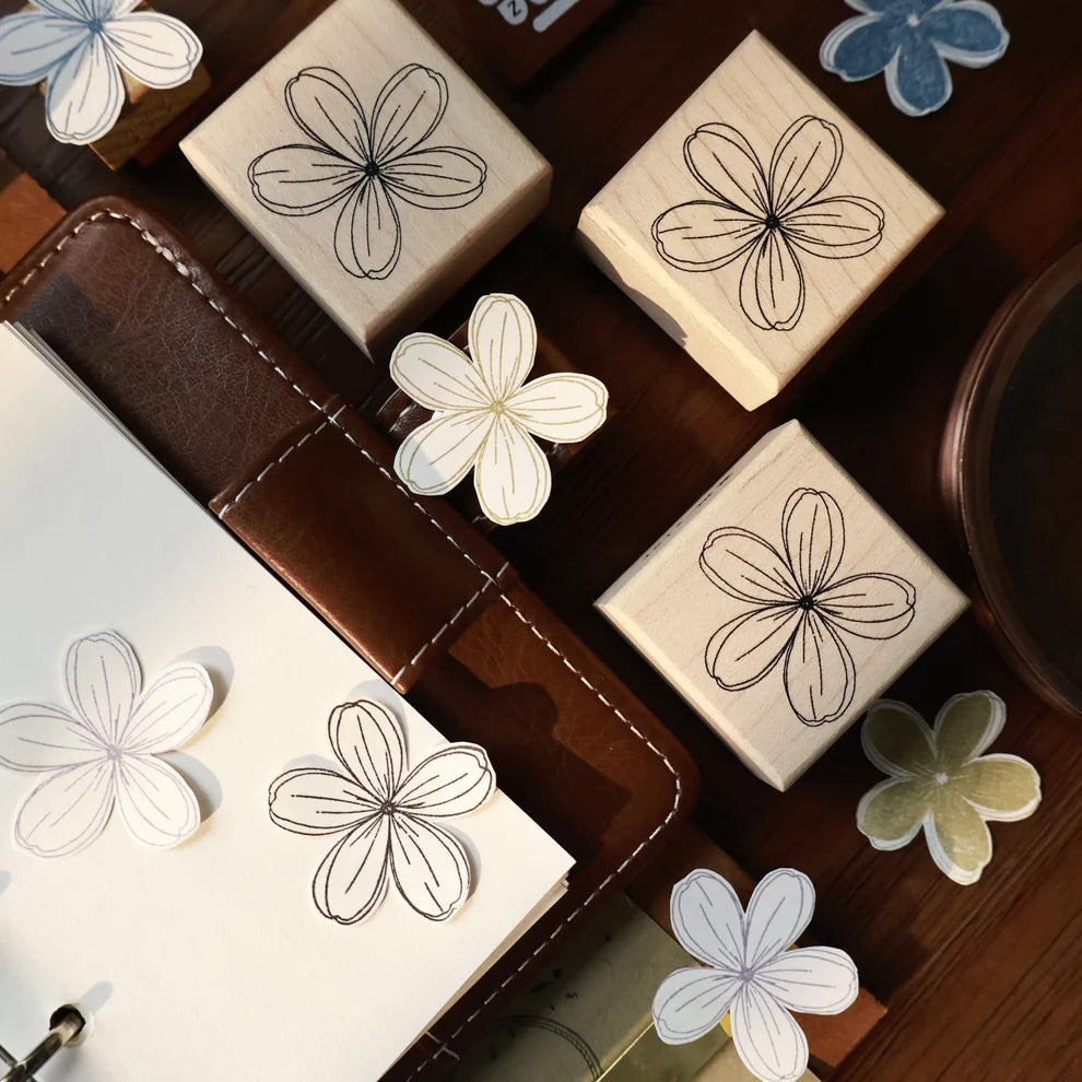 Streamline Flower Rubber Stamp by Yier flower-shaped stamp on wood with a pen and paper