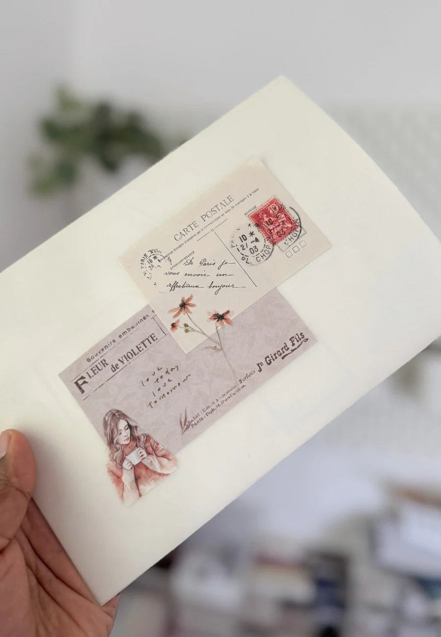 Hand holding vintage-style postcard ephemera – curated paper goods at the Avyanna Decore studio