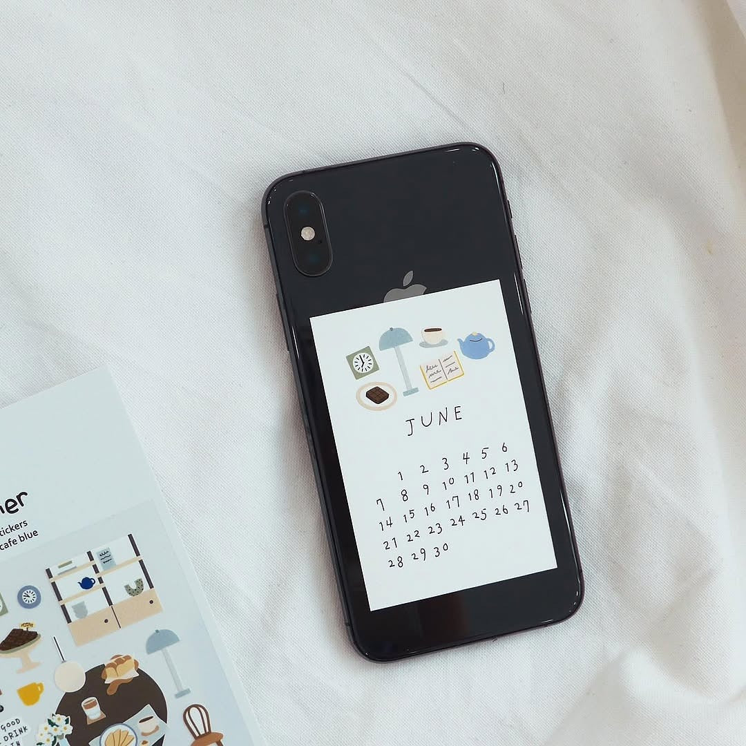 Phone with a calendar app open to June on a white surface, from the Café Blue Sticker Sheet