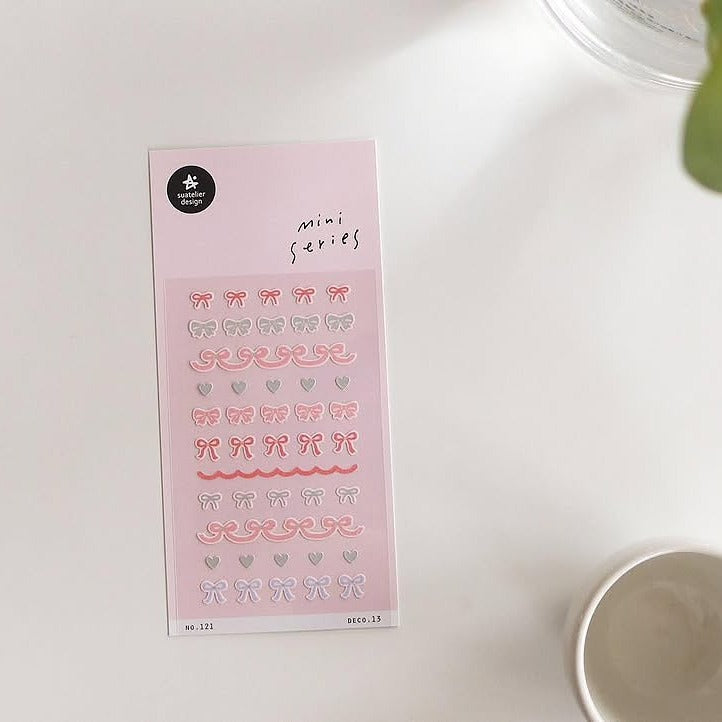 Deco 13 Sticker Sheet by Suatelier, bow and heart stickers on a pink background