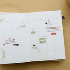 Open planner with stickers on a wooden surface
