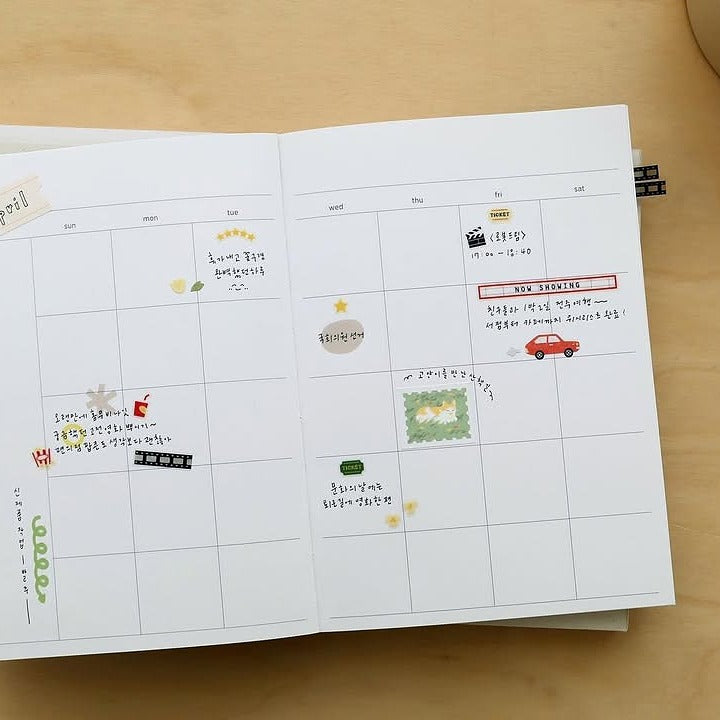 Open planner with stickers on a wooden surface, from the Deco 16 Sticker Sheet