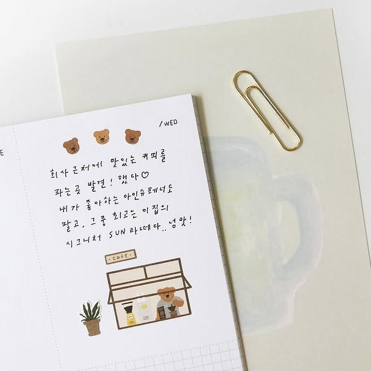 Notebook with stickers and a paper clip on a white background
