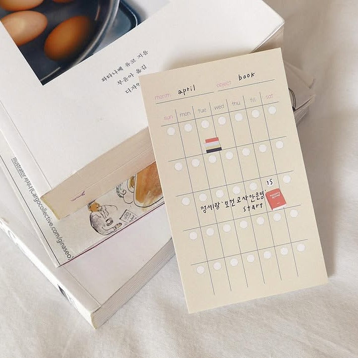 Notebook with a calendar page on top of an open book, from the In The Library Sticker Sheet