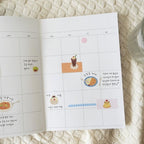 Calendar with food-themed stickers on a textured surface