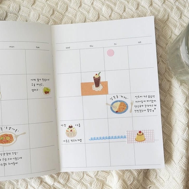 Calendar with food-themed stickers on a textured surface, from the Kissaten Sticker Sheet