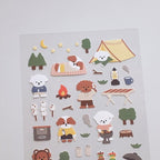 Sheet of camping-themed stickers with cartoon animals and outdoor items on a gray background