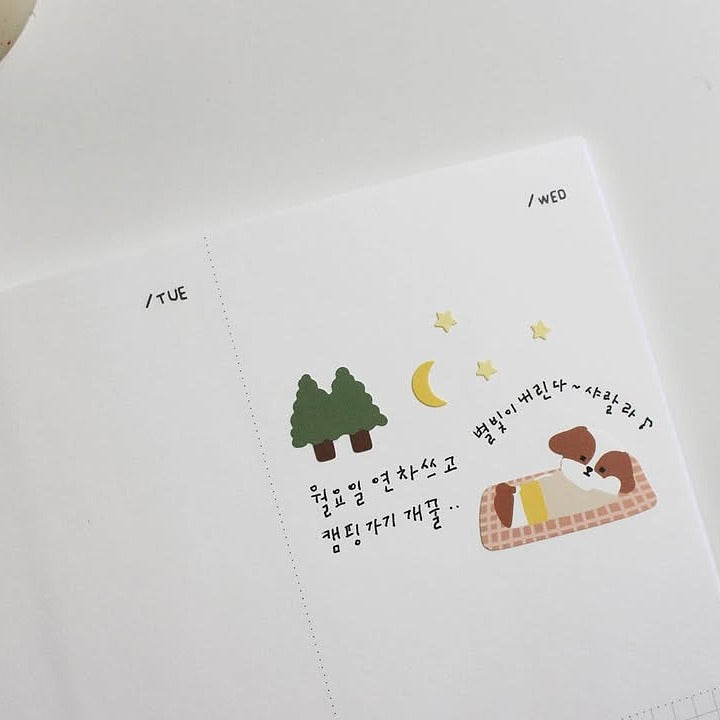 White fabric embroidered with two dogs on a blanket, trees and stars, from the Let's go Camping Sticker Sheet