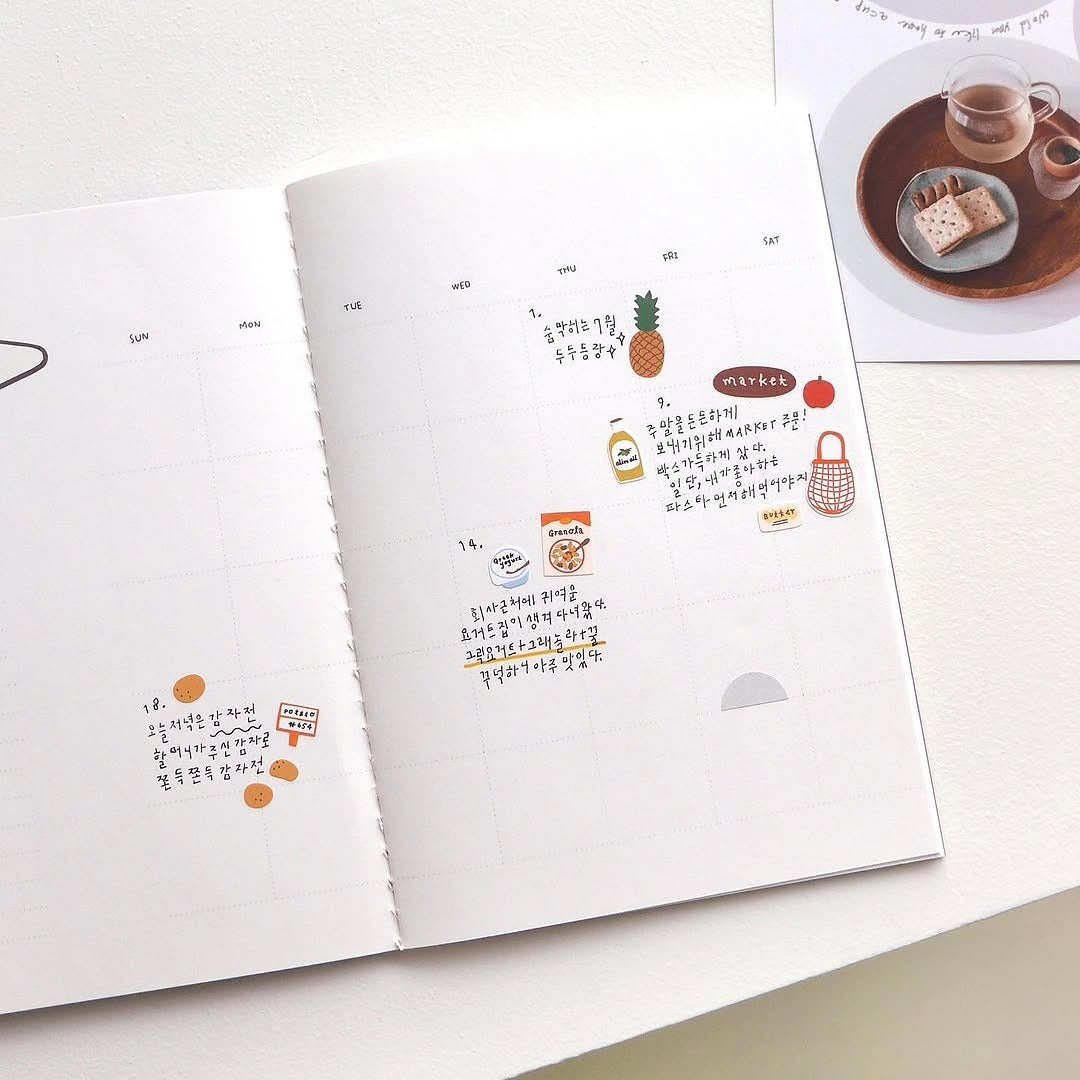 Open book with illustrations and text on a white surface, from the Market Sticker Sheet