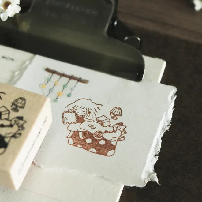 Rubber stamp with a design of a child playing with toys on a piece of paper.