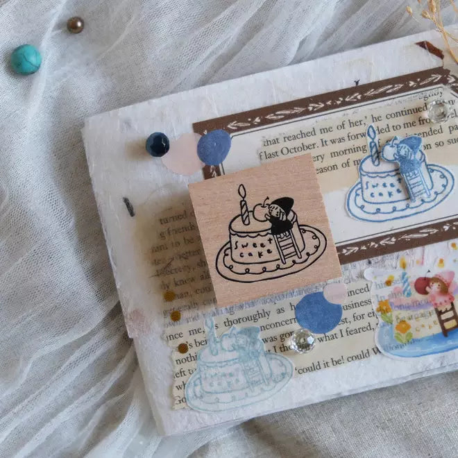 Simple Happiness Sweet Cake stamp with a cake and cat design on a textured surface, close-up