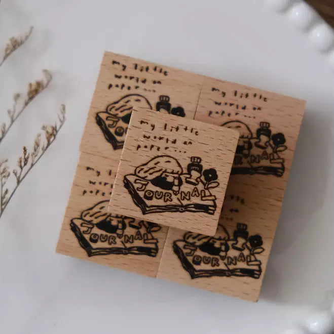 Set of My World on Paper wooden stamps with illustrations and text on a white surface
