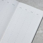 Open planner with grid layout on a textured surface